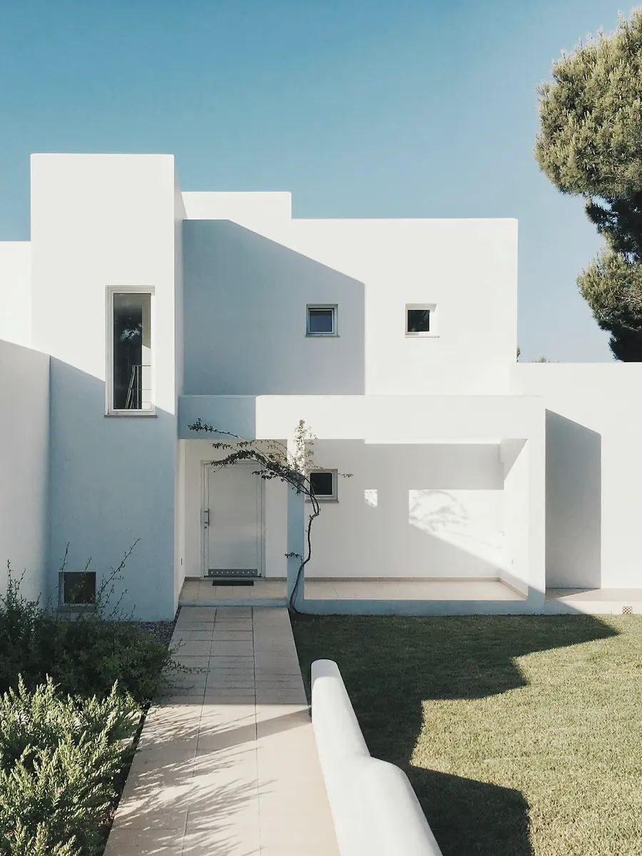 Vivienda unifamiliar blanca de obra nueva con jardín