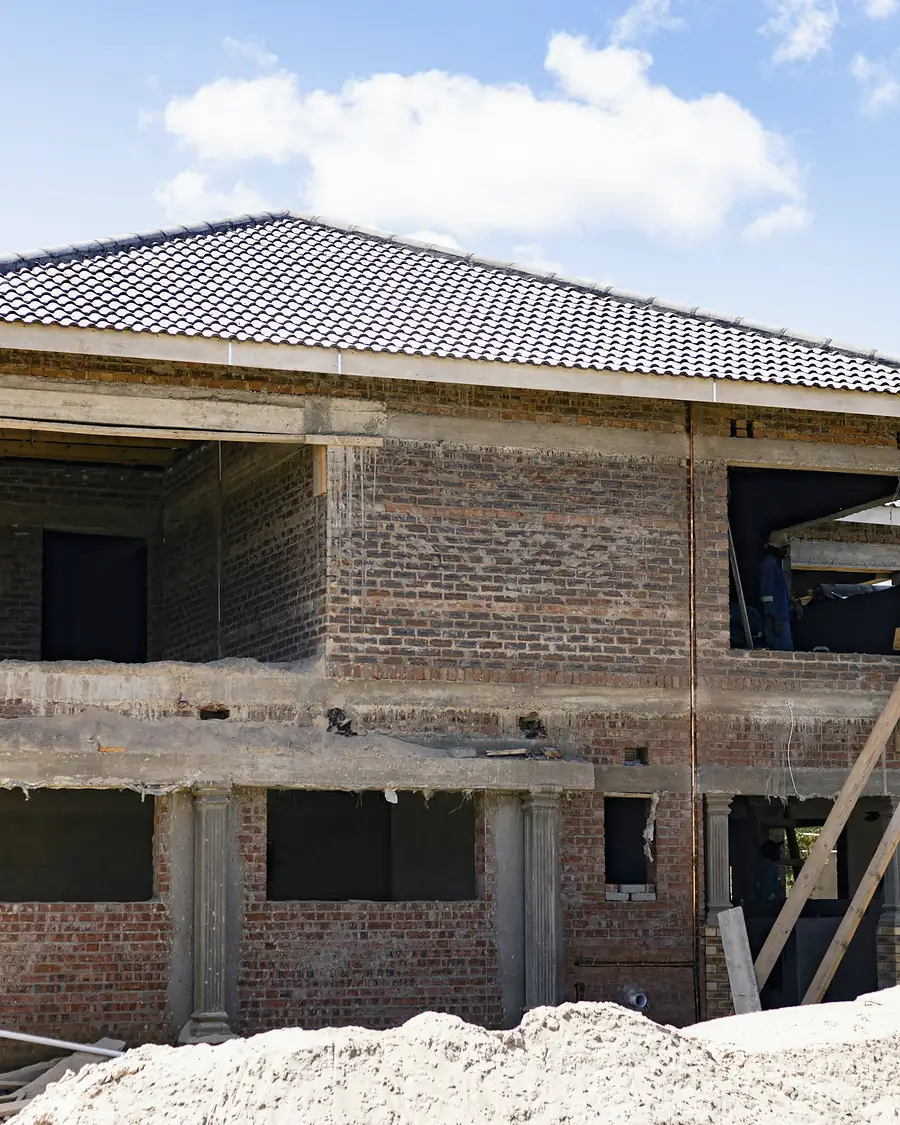 Vivienda en construcción con muros de ladrillo y cubierta de teja